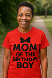 Load image into Gallery viewer, Happy woman wearing a red t-shirt with &#39;Mom of the Birthday Boy&#39; text and a bow graphic outdoors.