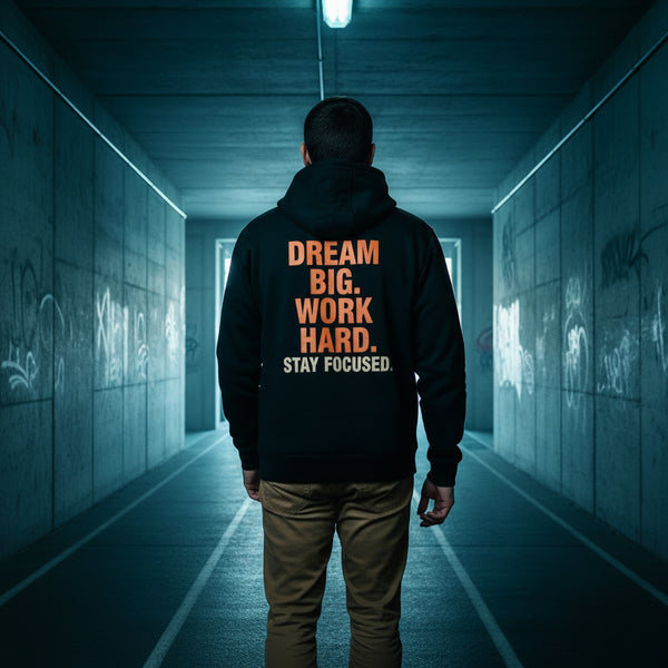 Person wearing a black hoodie with motivational text on the back, standing against a white background